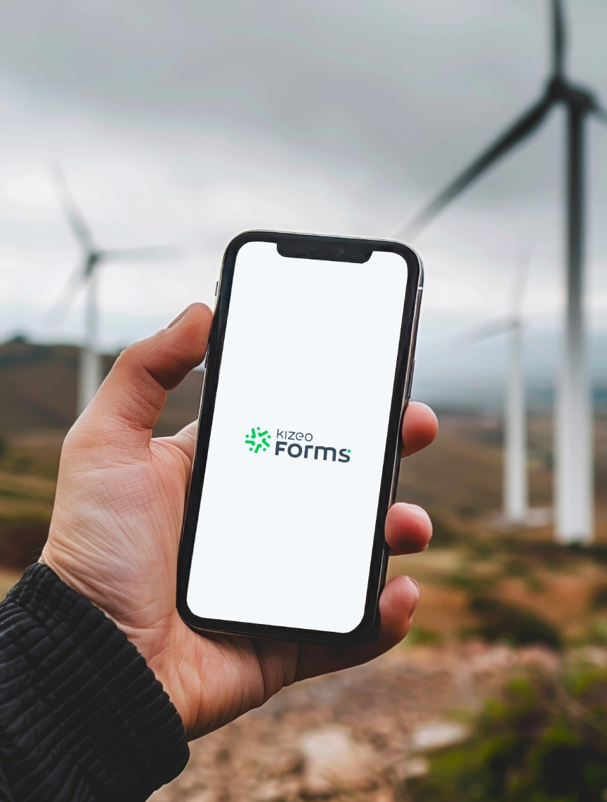 Homme tenant un tlphone avec lapplication Kizeo Forms dans un champ dolienne